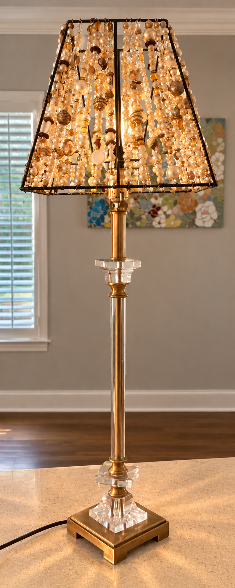Completed champagne-toned Beaded Light illuminated on its crystal and brass base