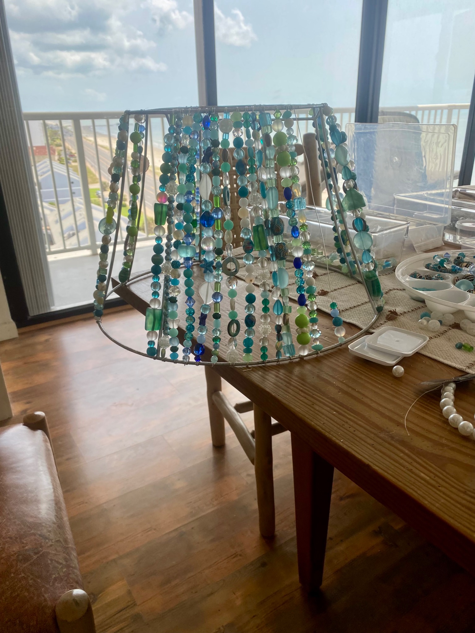 Blue green beaded shade in progress on a worktable