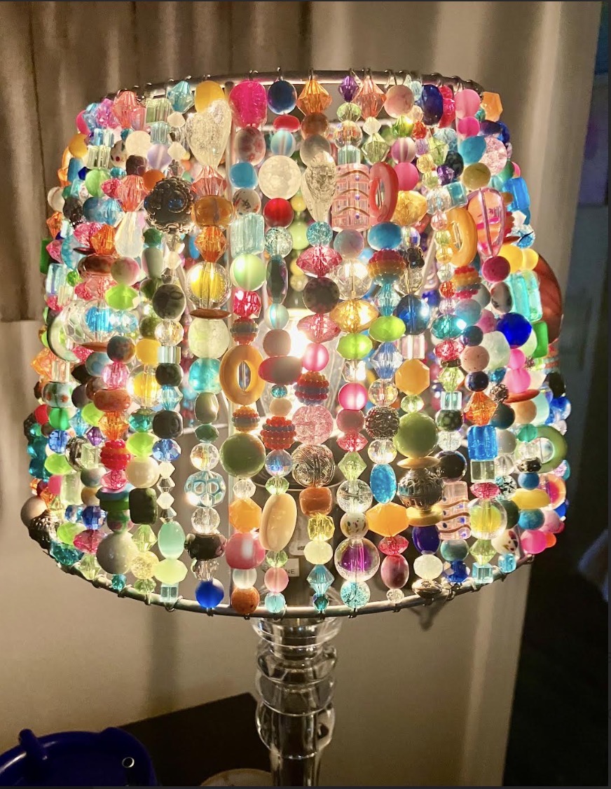 Completed multicolor Beaded Light glowing on a clear lamp base
